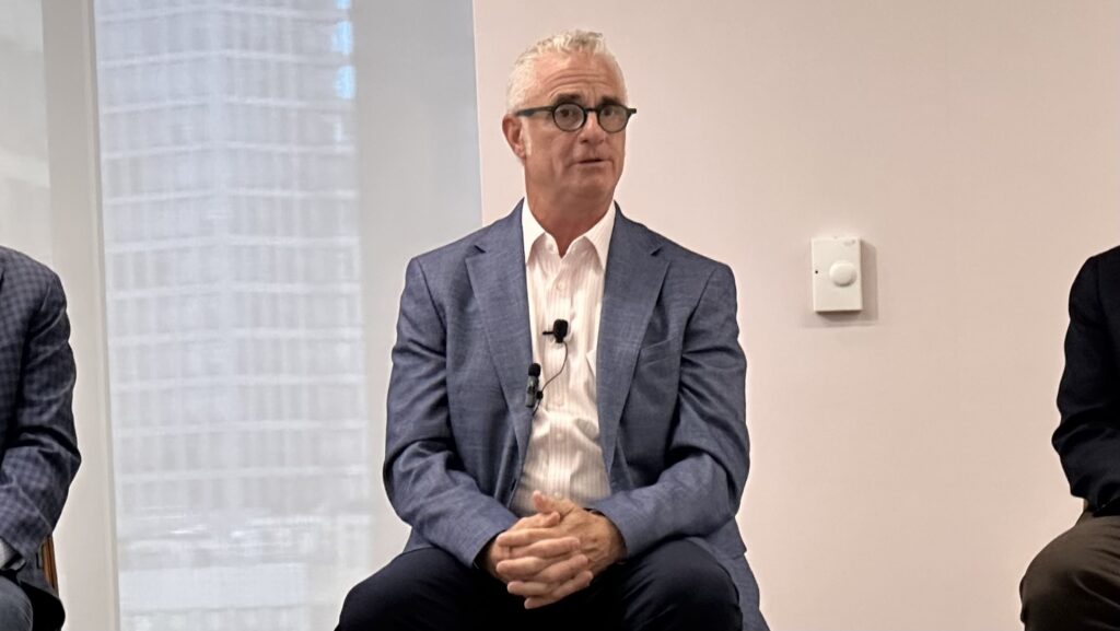 Jonathan Sheppard of J. Sheppard Associates seated on a panel with a microphone